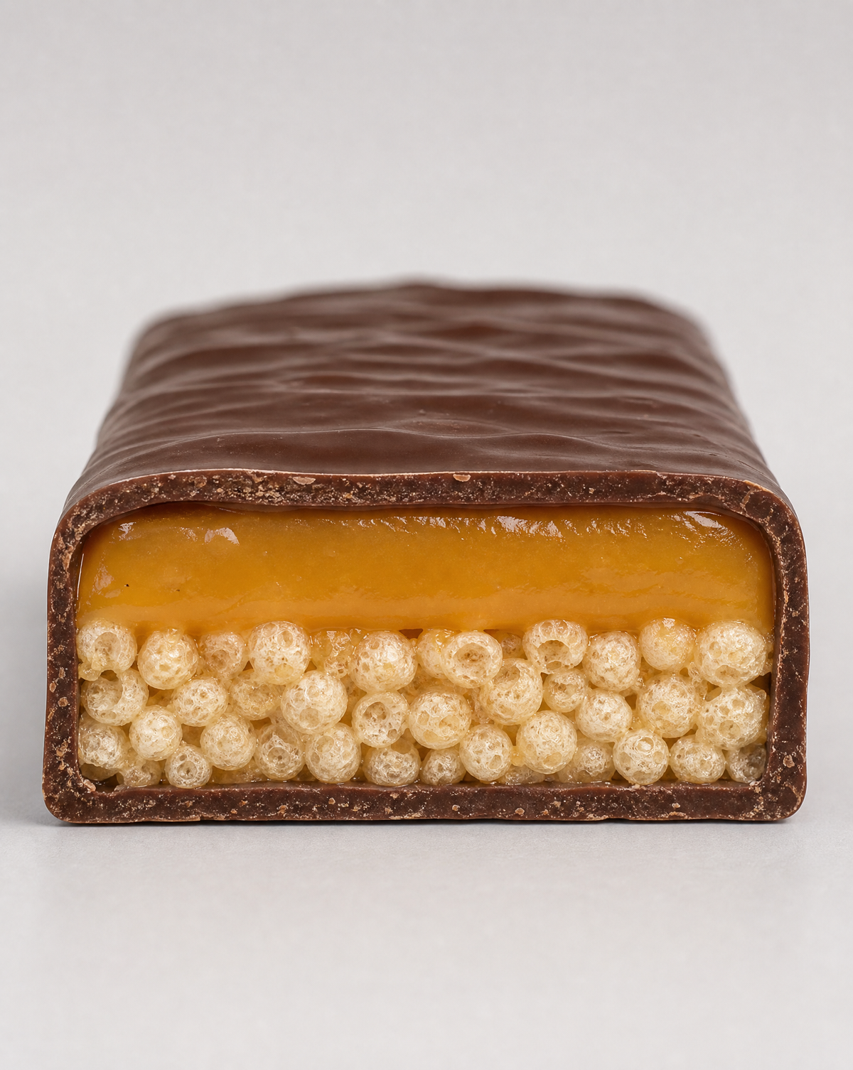 Cross-section of the crispy chocolate caramel bar showing the caramel layer and rice crisps