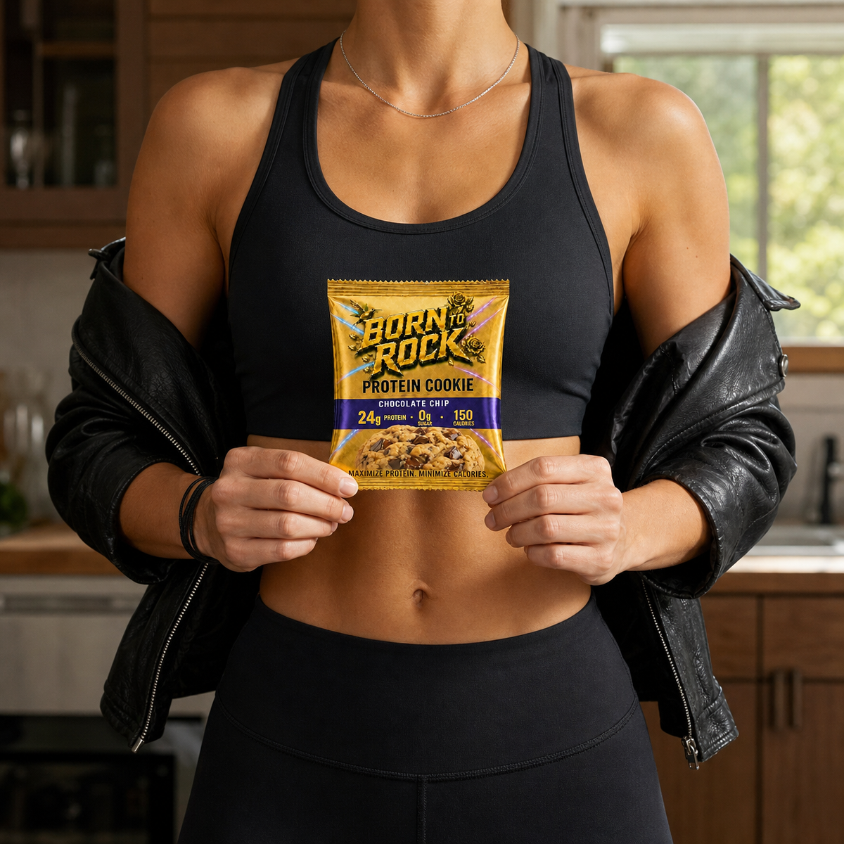 Holding the Born To Rock Protein Cookie pack in a kitchen